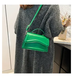 Detail of green candy color handbag with 3D embossed flap and adjustable shoulder strap