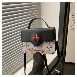 Close-up of cute cherry print on the stylish black and white contrast crossbody bag