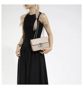 Detail of beige flap bag featuring smooth leather, woven texture and silver metal lock