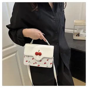 Close-up of cute white cherry print crossbody bag with 3D cherry buckle shown on model
