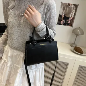 Elegant black leather tote bag with knotted handles and adjustable shoulder strap
