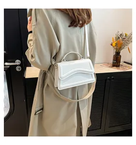 White crossbody bag featuring a unique wavy layered flap design for a stylish look