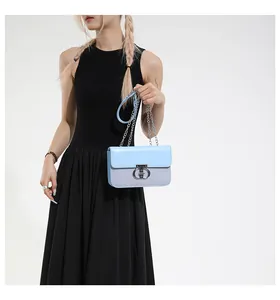 Detail of light blue crossbody bag with silver chain and textured spliced design