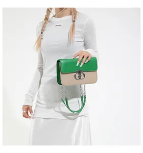 Close-up of contrast crossbody bag with green leather flap and silver metal buckle