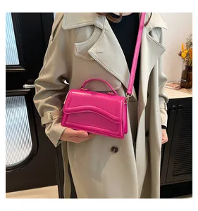 Detail of trendy magenta crossbody bag with wave flap design and sleek leather texture