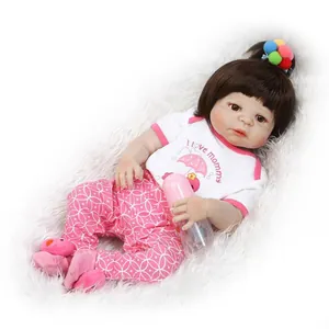 Lifelike reborn baby doll wearing I Love Mommy shirt and pink pants with bottle