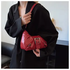 Detalle del bolso baguette vintage rojo con textura brillante y hebilla de plata