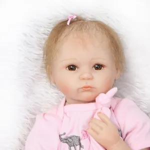 Poupée bébé reborn réaliste avec nœud rose et broderie éléphant sur fond en peluche