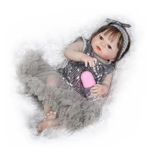 Realistische Neugeborenen-Puppe in grauem Spitzenkleid mit rosa Fläschchen auf Plüsch
