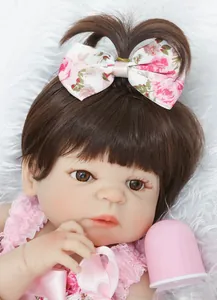 Gros plan d'une poupée reborn réaliste avec cils et vêtements en dentelle rose