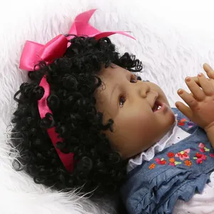 Muñeca de bebé africana realista con pelo rizado y vestido de mezclilla bordado