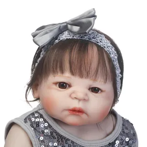Realistische Reborn-Babypuppe mit braunem Haar und Pailletten-Stirnband in Grau