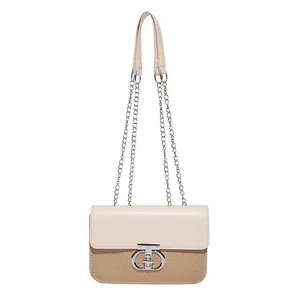 Elegant beige chain shoulder bag with a silver circular clasp and textured patchwork