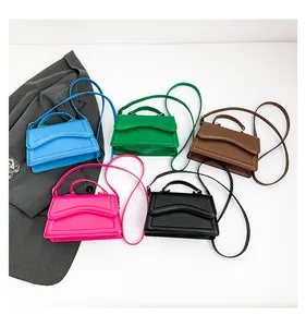 Flat lay of colorful minimalist crossbody bags in blue green pink brown and black leather