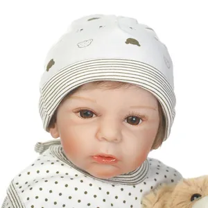 Realistic reborn baby doll with brown eyes and white patterned hat for holiday gifts