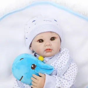Lifelike reborn baby doll in blue polka dot outfit with matching hat holding a plush toy
