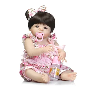 Détails d'une poupée reborn avec robe à fleurs, sucette rose et accessoires de biberon