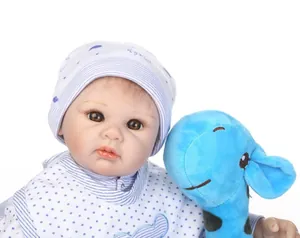 Close-up of the realistic reborn doll with eyelashes and a blue giraffe plush toy