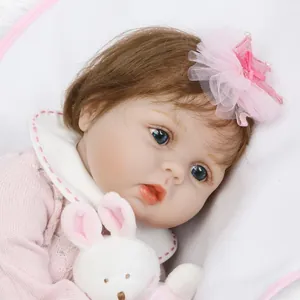 Poupée bébé reborn réaliste avec yeux bleus, haut en tricot rose, couronne et lapin peluche