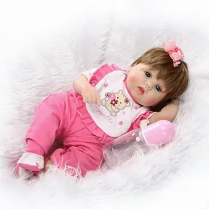 Lebensechte Reborn-Babypuppe in rosa Outfit mit Lätzchen und Flasche auf weißem Teppich