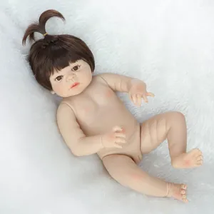 Vue détaillée du corps d'une poupée de nouveau-né réaliste sur un fond en peluche blanche