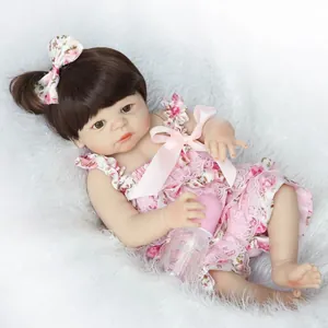 Gros plan détaillé d'une poupée reborn réaliste avec cheveux longs et robe rose