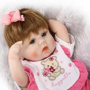 Realistische Reborn-Puppe mit braunem Haar und rosa Outfit auf weicher Plüschmatte