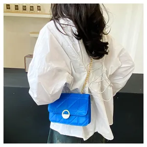 Blaue gesteppte Umhängetasche mit goldener Kette und Metallverschluss an einem Model