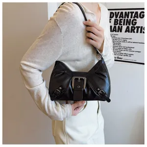 Detalle de un bolso de hombro vintage en cuero negro con hebillas grandes y textura suave