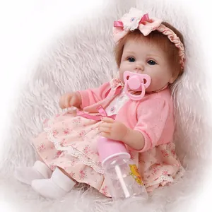 Lifelike reborn baby doll with brown hair and blue eyes in a pink floral outfit