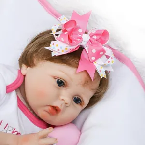 Cute pink polka dot ribbon bow headband on a realistic newborn reborn baby doll