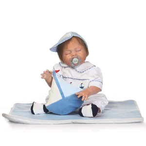 Lifelike reborn baby doll in blue nautical outfit with sailor hat and plush sailboat toy