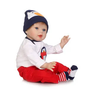 Realistic reborn baby doll in cute penguin outfit with hat and striped socks