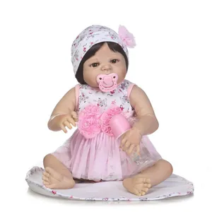 Lifelike reborn baby doll in pink mesh dress with floral hat, pacifier and bottle