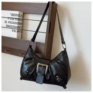 Detail van vintage zwarte leren schoudertas met zilveren metalen gespen en plooien
