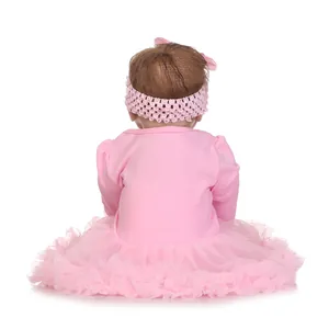 Realistic reborn baby doll in pink tutu dress and bow headband from a back view