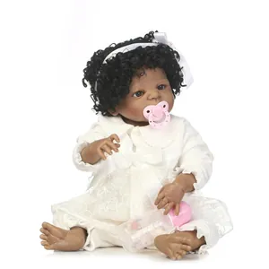 Poupée bébé réaliste peau foncée aux cheveux bouclés en tenue de velours blanc