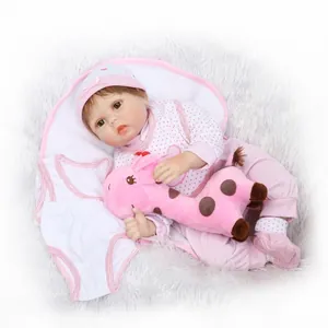 Reborn-Babypuppe mit gestreiftem Outfit und rosa Giraffe auf grauem Plüsch-Hintergrund