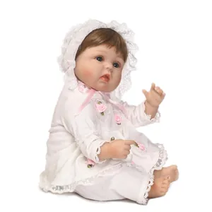 Poupée nouveau-né réaliste en robe de dentelle blanche avec roses et bonnet rose