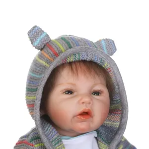 Realistic reborn baby doll in a grey knit hoodie with rainbow ears and cute facial features