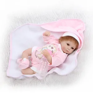 Poupée bébé reborn réaliste en grenouillère rose avec biberon sur tapis en peluche