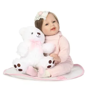 Realistic reborn baby doll in pink knit outfit with plush bear and lace headband