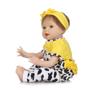 Muñeca reborn realista con diadema floral y pantalones con estampado de vaca