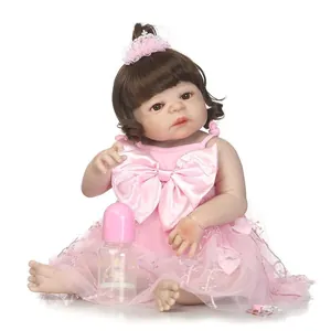 Realistic reborn baby doll with brown curls in pink tutu dress and headband with bottle