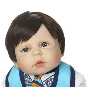 Lifelike reborn baby doll with blue eyes and short brown hair in blue necktie outfit