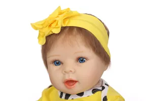 Primer plano de muñeca reborn realista con ojos azules y diadema de flor amarilla