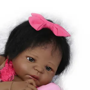 Realistic African American reborn baby doll with curly hair and pink lace outfit