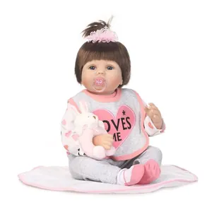 Poupée bébé reborn réaliste avec cheveux bruns, yeux bleus et accessoires roses