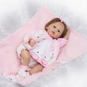 Realistische Reborn babypop in roze konijnenpakje met knuffel en zachte pluche achtergrond
