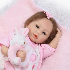 Realistische herboren babypop in roze polka dot outfit met een pluche konijn accessoire